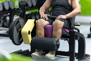 Boy Doing Exercises at Gym: Leg Extensions Workout on Fitness Machine