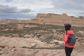 Young woman mountain bike cyclist in Badlans of Navarre (Bardenas Reales de Navarra) dessert in the middle of Spain.