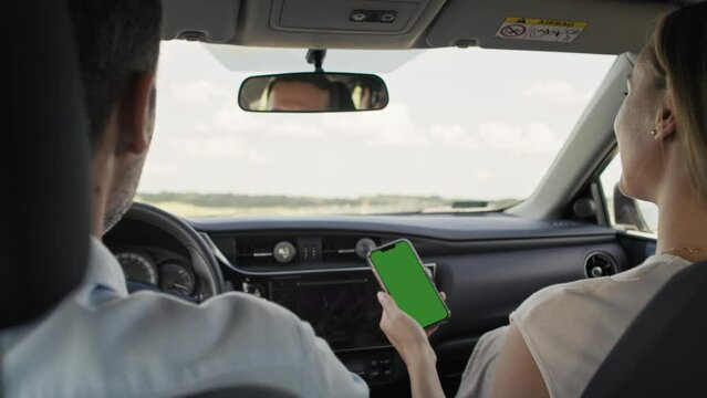 Rear view of  middle age caucasian couple driving a car and using map on smart phone. Shot with RED helium camera in 8K.