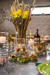 Banquet table served for holiday with canape and different snacks, wine glasses, candles and flowers. European food. Catering.