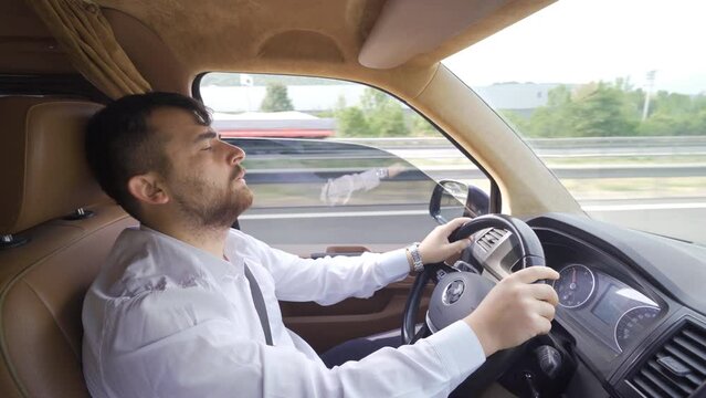 Tired and sleepy driver.
The man closes his eyes and falls asleep while driving.
