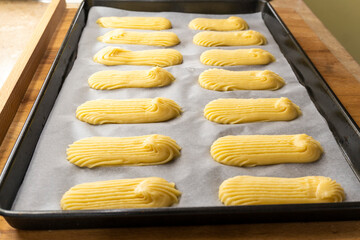 raw eclairs on a baking sheet. food concept. dessert