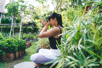 Asian girl practicing yoga in sunny yard outdoor