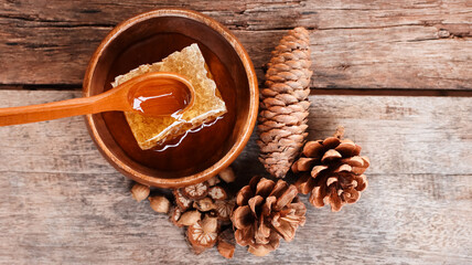 Honey and honeycomb with wooden spoon on wooden table