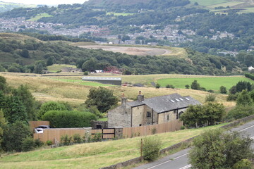 Fototapeta na wymiar Village in the valley surrounded by hills and countryside. Taken in Lancashire England. 