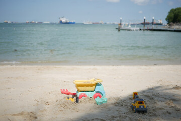  multi-colored plastic toys on a large sea sandy beach 