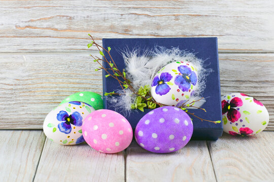 Easter egg in a box with feathers and twigs