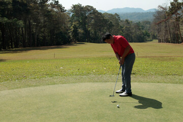Obraz premium Golfers are putting golf in the evening golf course golf backglound. Golfer hitting golf ball.