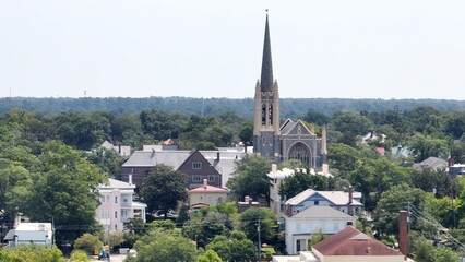 Fototapeta na wymiar Church with steeple rises about urban neighborhood