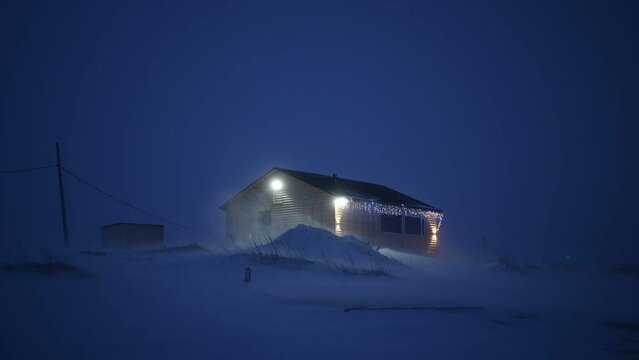 Handheld footage of lonely house during the snow blizzard at night