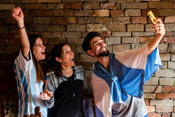 Familia sacandose una selfie en la previa antes del mundial de futbol, con picadas y cervezas,  con...