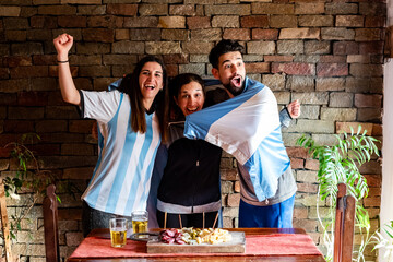 Familia en la previa antes del mundial de futbol, con picadas y cervezas,  con los colores celeste...