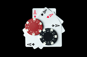 Playing cards with a winning combination of four of a kind or quads and chips on a black table in a club