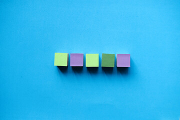 Colorful wooden blocks isolated on a light blue background © Kanurism
