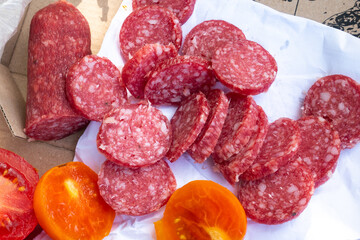 Tomatoes and sausages on the bay. Picnic on the nature. Good in village. Rustic style.