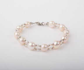 Genuine pink pearl bracelet decorated with bead isolated on white background