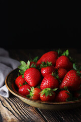 A bowl with ripe bright strawberry in rustic style	