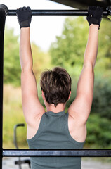 Fototapeta premium 36 year old white woman showing her back, doing pull ups, Belgium