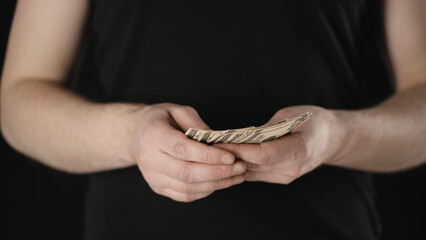 cropped view of man counting dollar banknotes isolated on black