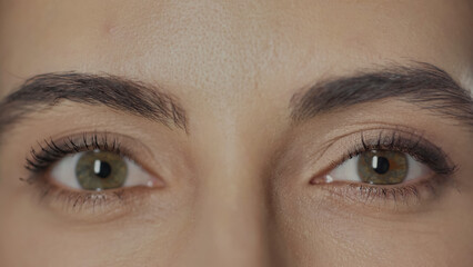 close up view of woman with hazel eyes and mascara on eyelashes looking at camera