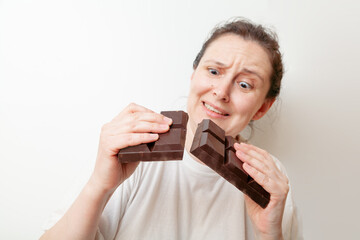 Young woman breaks a huge bar of chocolate....