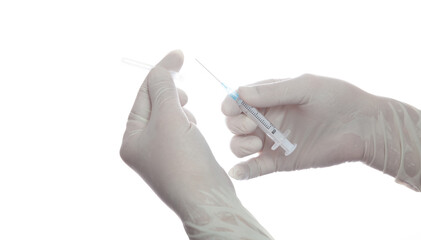 Hands in medical gloves remove cap of   needle in syringe....