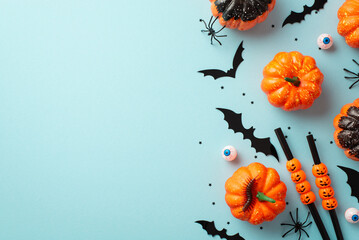 Halloween party concept. Top view photo of pumpkins bat silhouettes spiders centipede eyeballs cocktail straws confetti on isolated pastel blue background with copyspace
