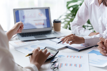 Business people point to graph and chart to analyze market data, balance sheet, account, net profit to plan new sale strategies to expand productivity.