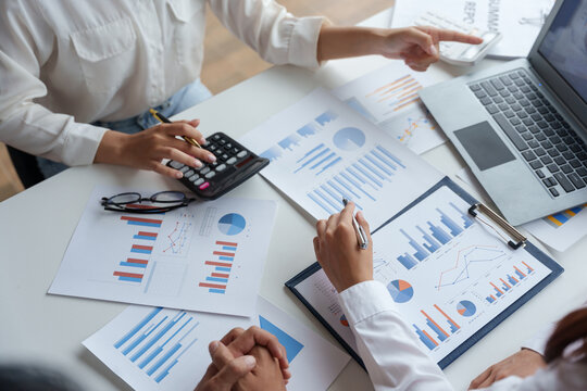 Business people point to graph and chart to analyze market data, balance sheet, account, net profit to plan new sale strategies to expand productivity.