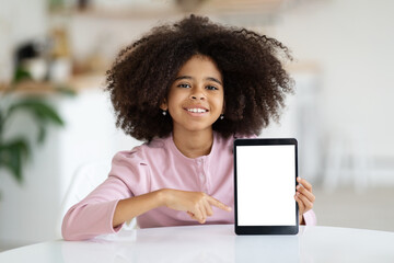 Cute black girl schooler showing digital tablet, mockup