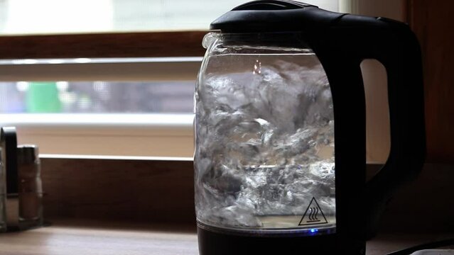 Transparent kettle with boiling water close-up. The process of boiling water. Slow motion