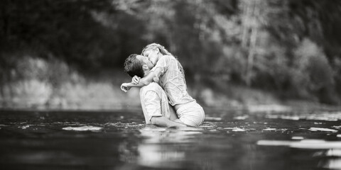 Guy and girl kiss standing in the water.