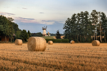 Straw bales in a field at sunset