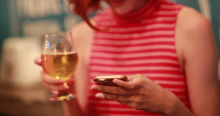 Girl checking cellphone while holding beer, real life laugh and smile