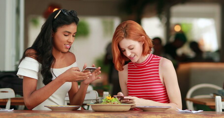 Diverse girlfriends together showing cellphone screen to friend