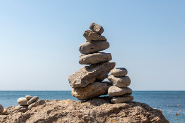 Close-up of stacked pebbles on the beach against a clear sky