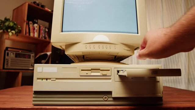 Using diskette for old computer. Music recorder, playing retro computer games. Vintage device for office, obsolete technology. 