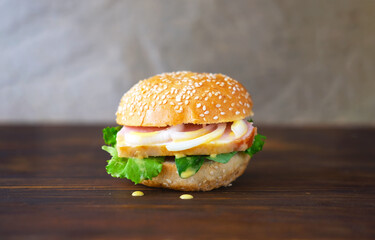 Sandwich with bacon and onion on semmel roll served on texture of old newspaper on rustic background. Creative space for sandwich day design. 
