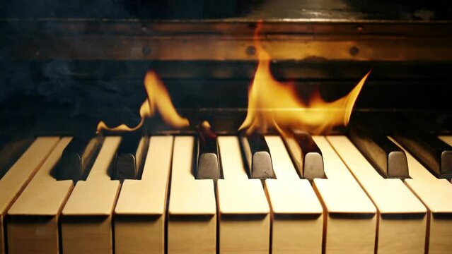 Burning piano keys. Slow motion fire flames and smoke.