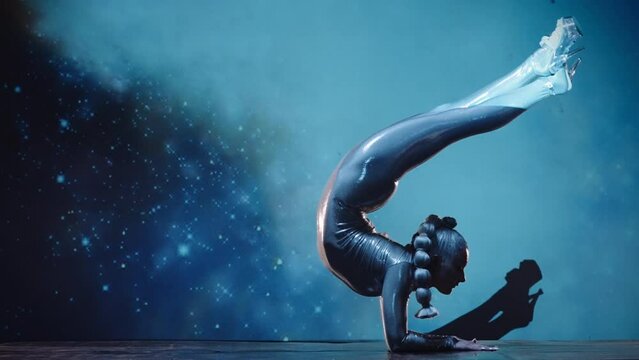 Flexible Woman Contortionist Performing on Stage Against Starry Space Back