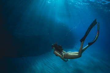 a girl dives in apnea in Mediterranean sea