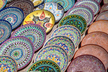 Decorative ceramic plates with traditional uzbek ornament in the street market of Bukhara....