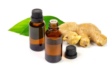 Ginger essential oil in bottle and fresh ginger with green leaf isolated on white background. The scientific name is zingiber officinale. Herbs for health care concept.