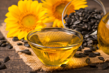 Fototapeta premium Sunflower oil and sunflower seeds on traditional rustic wooden background. Organic and eco food concept. Healthy food and fats.