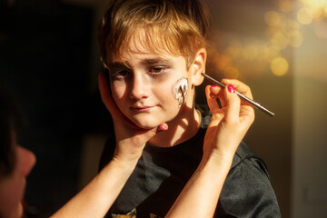 Obraz premium animator draws cobwebs on boy's face on halloween