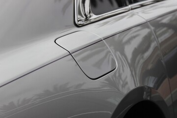 Side view of sleek sedan car, natural reflective lighting. New car at dealership background image. With copy space. 
