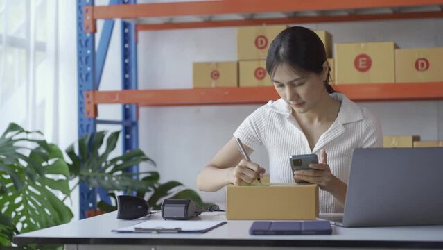 A woman in an e-commerce business inspecting the product before sending it to the customer. She does business on websites and social media. concept of selling products online sme