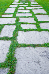 Old paving in a public park made with irregularly shaped stone blocks in a pedestrian zone and...