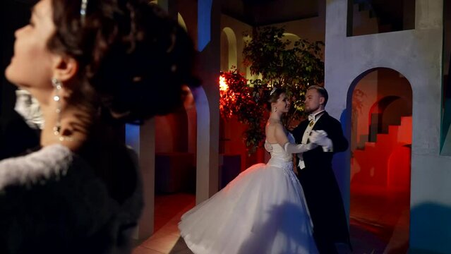 fabulous dancing ball in royal castle, women in gorgeous gowns and men in tailcoats dancing waltz