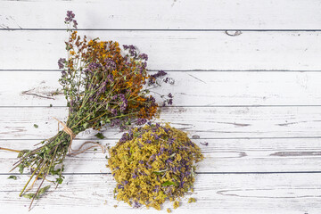 Bouquet of dried herbs and flowers on white wooden background.